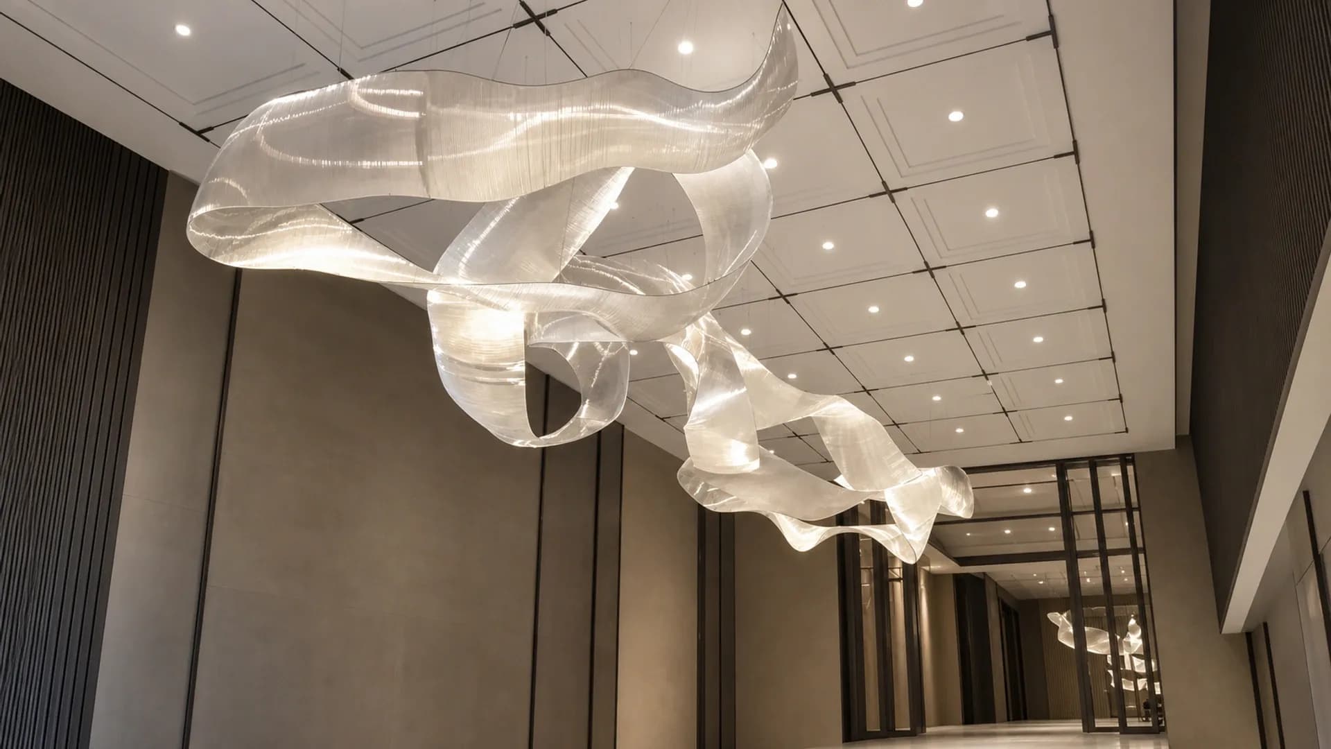 Ribbon-like bespoke lighting installation extending through an architectural corridor