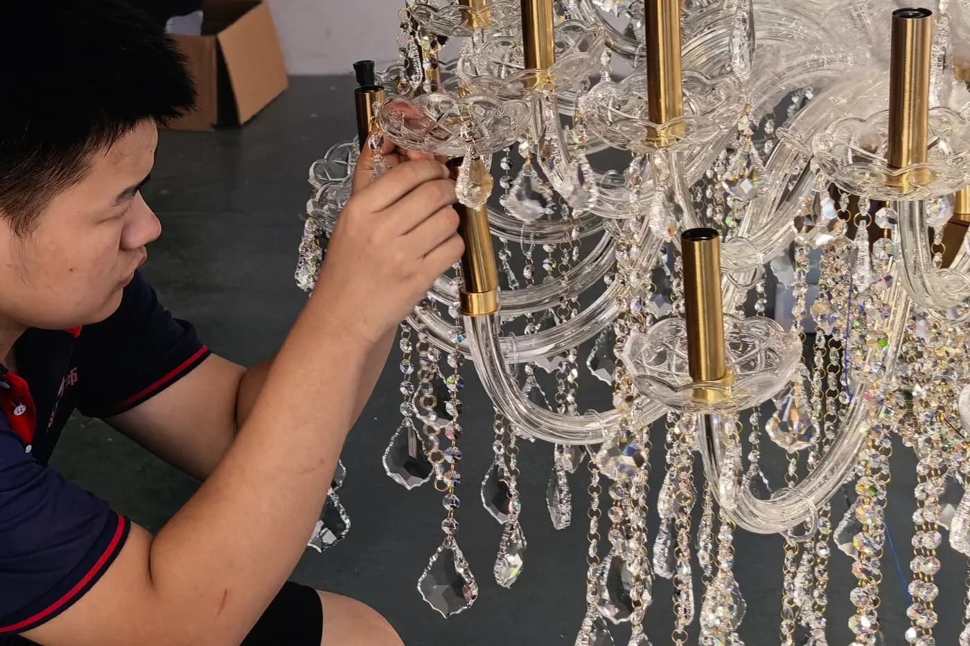 Installing crystal components by hand during chandelier assembly