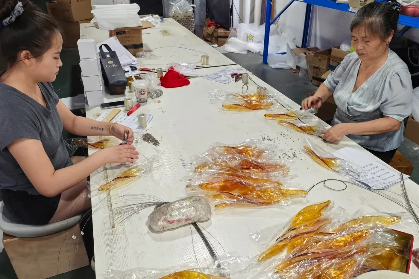 Team members assembling amber glass components by hand