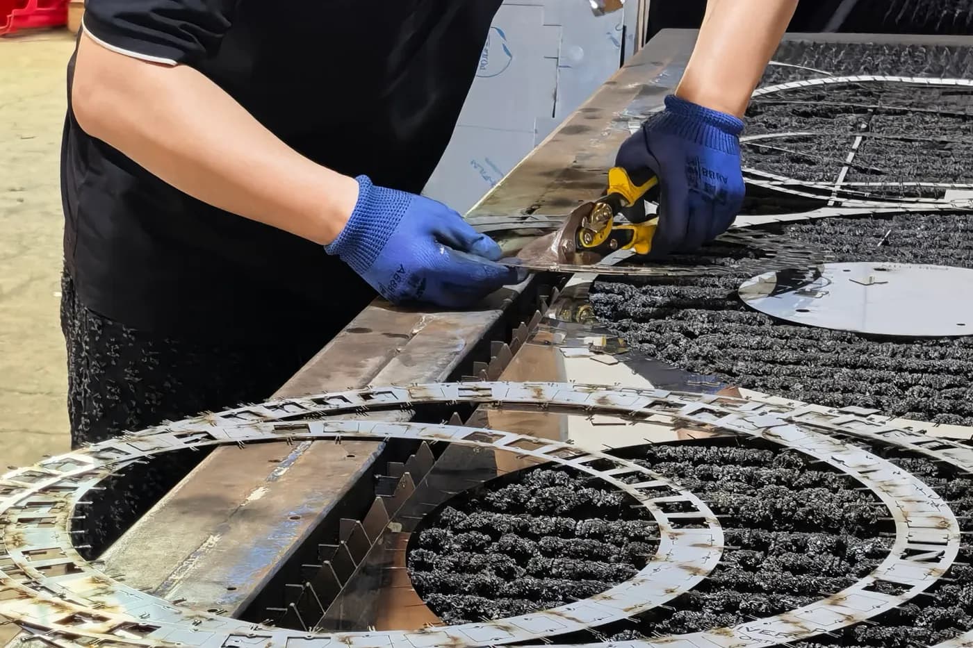 Hand-finishing laser-cut metal components for a custom lighting frame