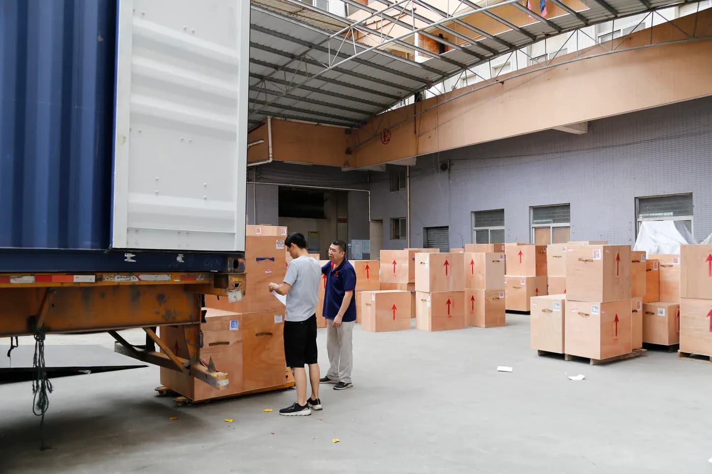 Wooden shipping crates prepared beside an export container